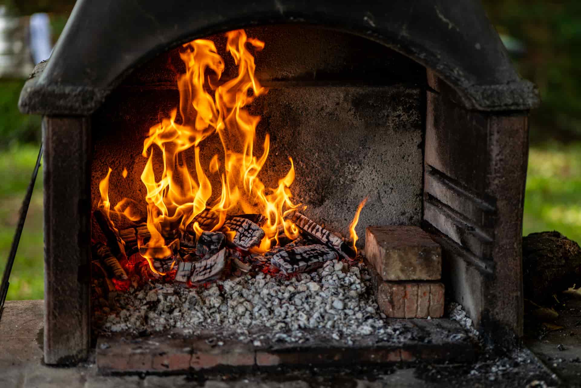A clay chiminea with flames visible through its opening