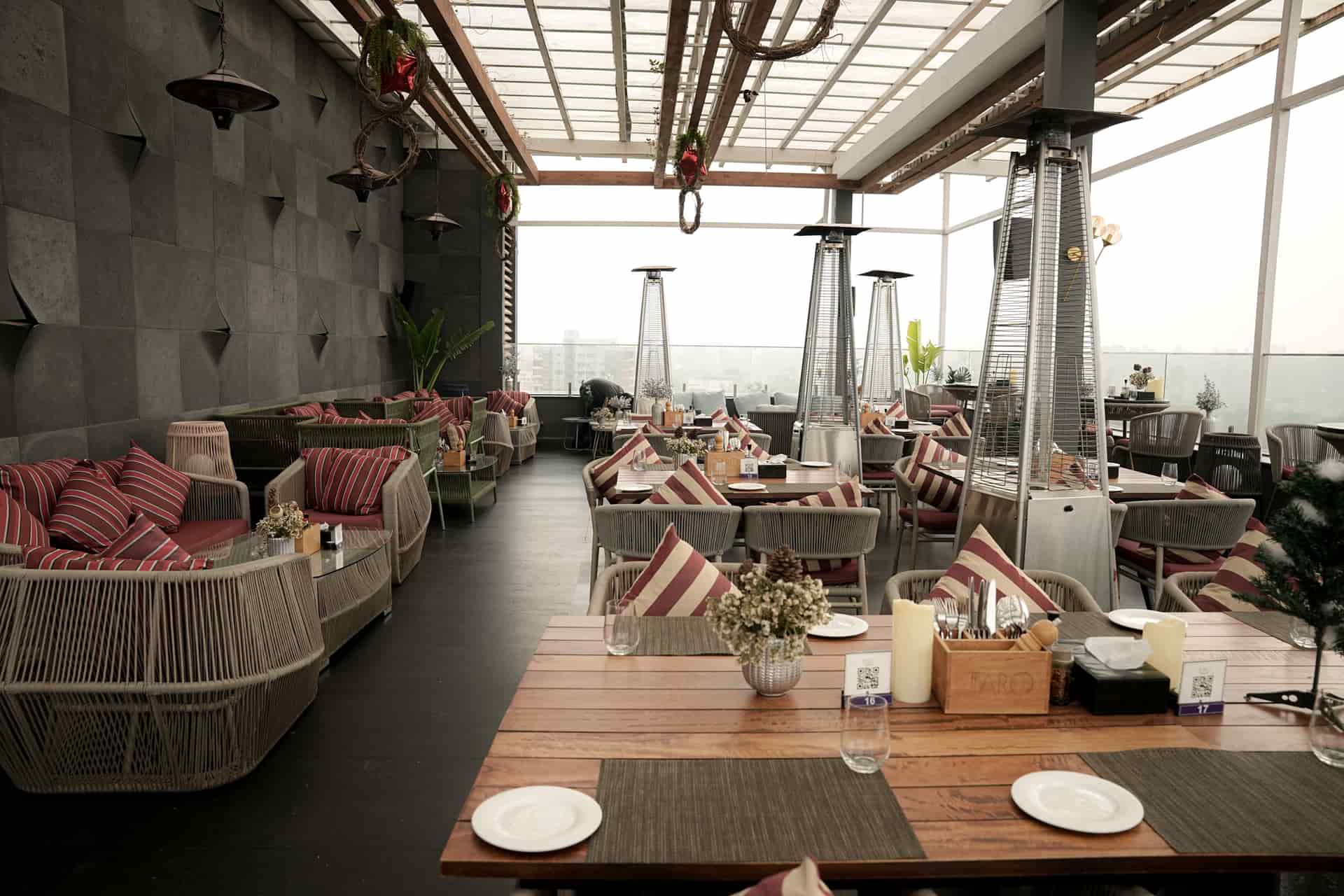 A covered outdoor seating area with pendant lighting at dusk