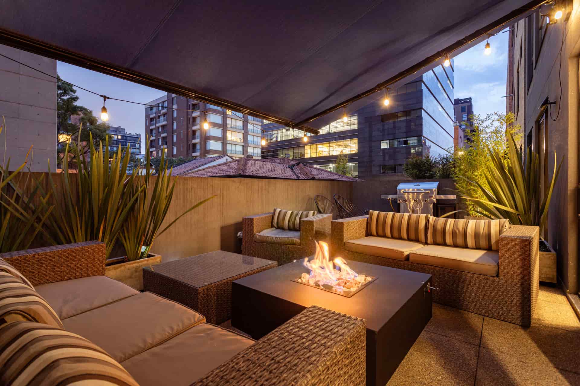 Outdoor furniture arranged around a patio table in the evening