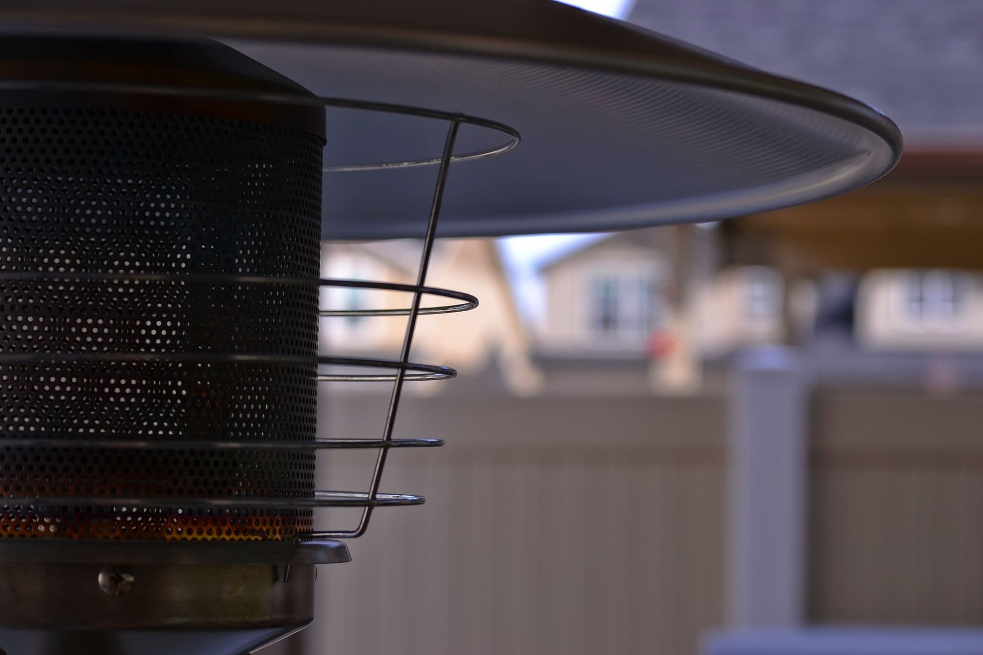 An infrared heat lamp glowing warm against a dark terrace