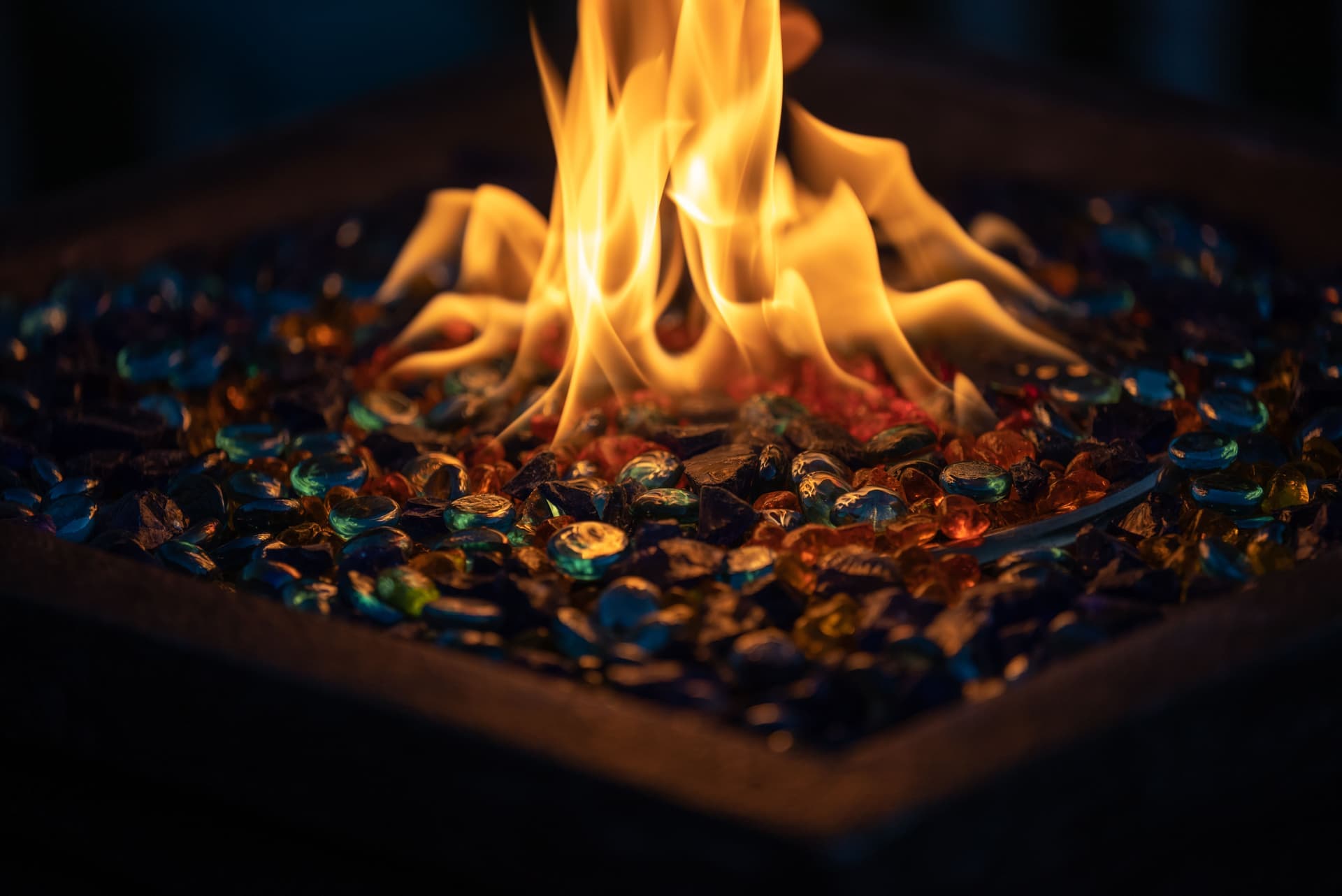 A wood fire burning in an outdoor fire pit at night