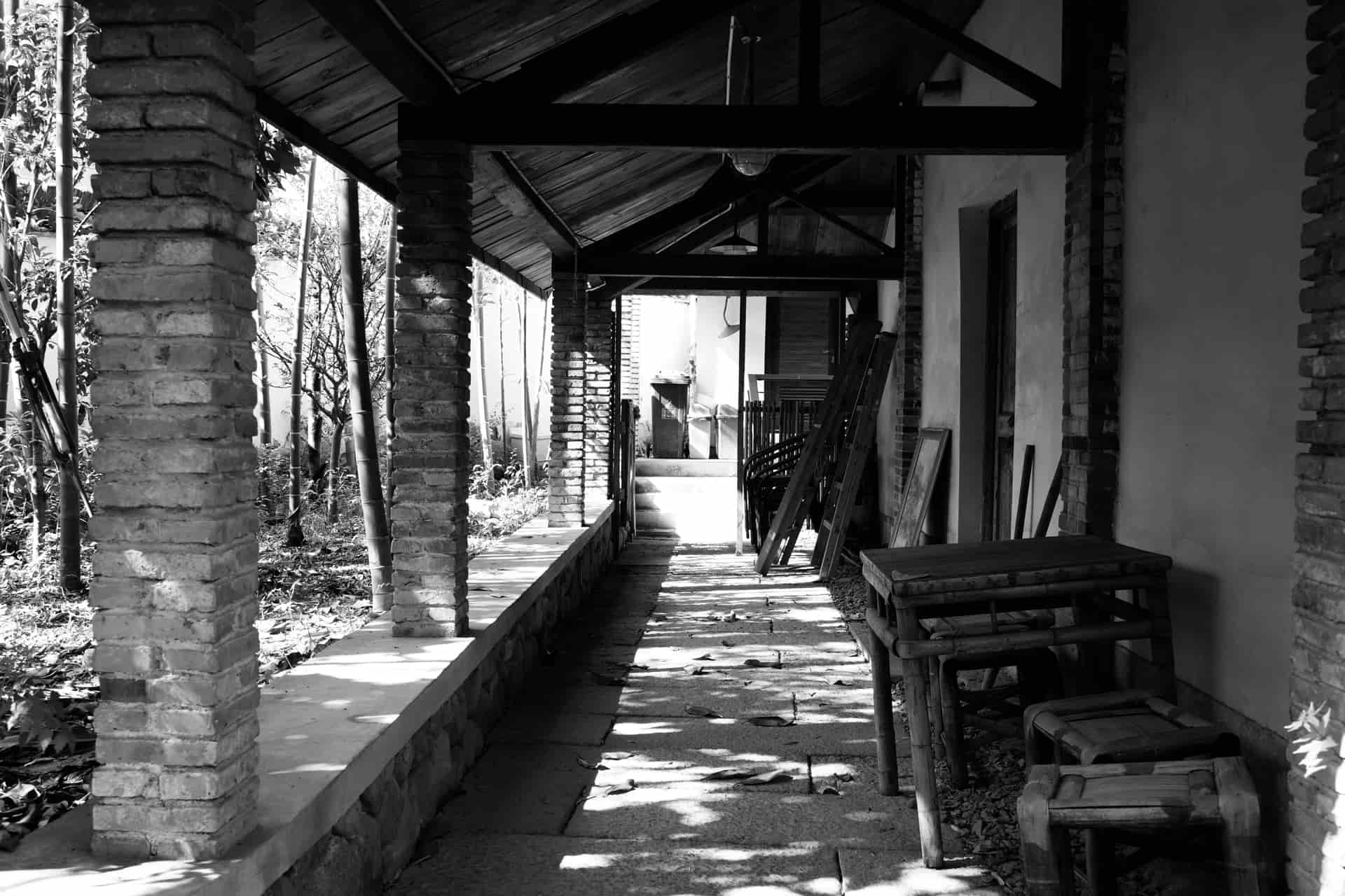 A covered walkway with a timber ceiling and seating along one side